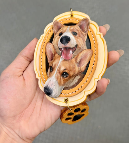 Finished yellow and ivory double corgi leather portrait charm held in a hand