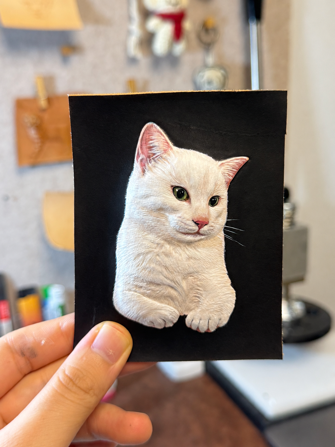White cat portrait carefully hand-colored after sculpting the leather